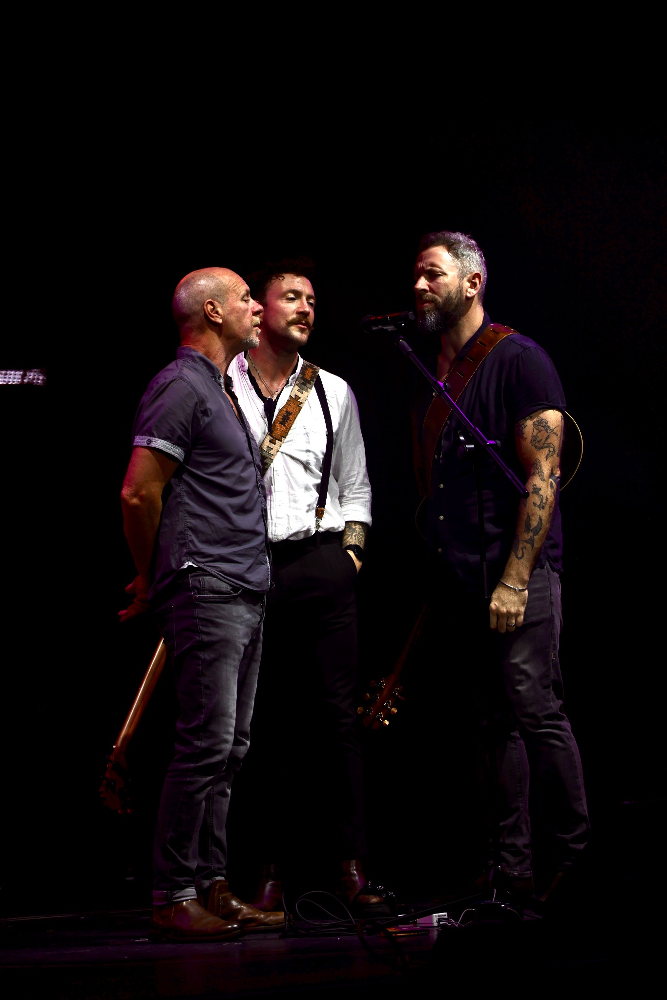 The Privateers singing together on stage